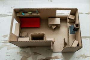 מבט עילי על דירה מיניאטורית מקרטון.