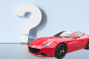 פרארי אדומה ליד סימן שאלה גדול.